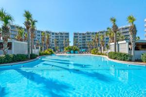 a large swimming pool with palm trees and condos at Destin West Gulfside #203 in Fort Walton Beach