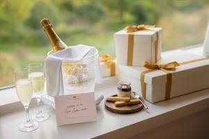 a bottle of champagne and wine glasses on a table with presents at Royal Garden Hotel in London