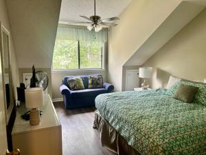 ein Schlafzimmer mit einem Bett und einem blauen Sofa in der Unterkunft Exquisite 3 bedroom, 3 bath villa - 19E West Hyde Park - Kingston Plantation villa in Myrtle Beach