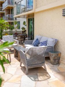 d'une terrasse avec des chaises en osier et un canapé. dans l'établissement Luana Waikiki Hotel & Suites, à Honolulu