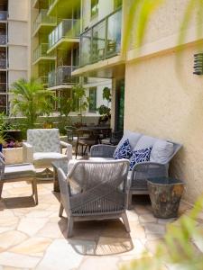 un patio avec des chaises et des tables dans un bâtiment dans l'établissement Luana Waikiki Hotel & Suites, à Honolulu