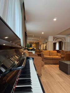 a living room with a piano and a couch at Hotel Meranda in Camigliatello Silano