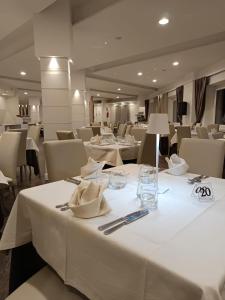 a dining room with white tables and chairs at Hotel Meranda in Camigliatello Silano