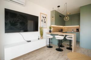 a kitchen with a counter and stools in a room at Apartment Oasis in Osijek