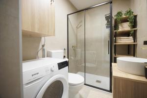 a bathroom with a washing machine and a toilet at Apartment Oasis in Osijek