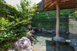 a garden with a stone walkway next to a building at Toushinan Komeya in Ito