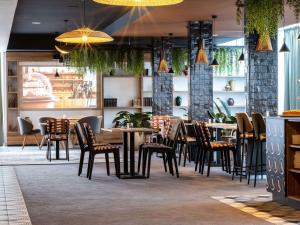 - un restaurant avec des tables et des chaises dans une salle dans l'établissement Novotel Chartres, à Chartres