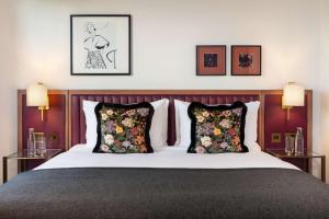 a bedroom with a large bed with two pillows at The May Fair, A Radisson Collection Hotel, Mayfair London in London