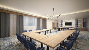 a dining room with a long table and blue chairs at voco Jeddah Gate, an IHG Hotel in Jeddah