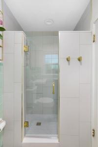 a shower with a glass door in a bathroom at The Poe - Stylish Studio in downtown High Springs in High Springs