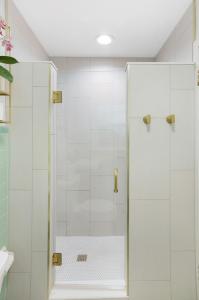 a shower with a glass door in a bathroom at The Poe - Stylish Studio in downtown High Springs in High Springs