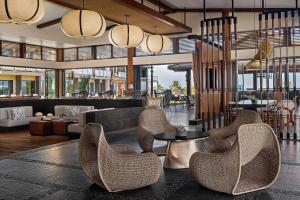 a lobby with chairs and a table and a bar at AC Hotel by Marriott Maui Wailea in Wailea