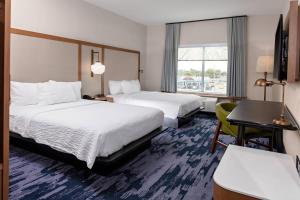 a hotel room with two beds and a desk at Fairfield by Marriott Port Clinton Waterfront in Port Clinton