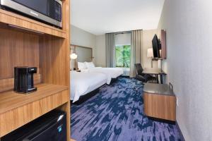 a hotel room with two beds and a tv at Fairfield by Marriott Inn & Suites Knoxville Airport Alcoa in Alcoa