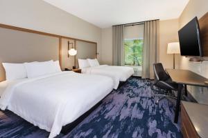 a hotel room with two beds and a flat screen tv at Fairfield by Marriott Inn & Suites Knoxville Airport Alcoa in Alcoa