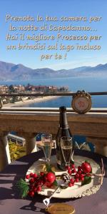 a table with a bottle of wine and a plate of fruit at Hotel La Rondinella in Cannero Riviera