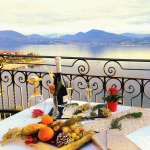 a table with fruits and wine glasses on a balcony at Hotel La Rondinella in Cannero Riviera