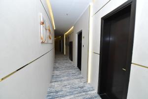 a corridor of a hallway with a black door at Palazzo hotel in Kuwait