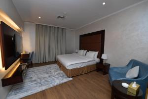 a hotel room with a bed and a blue chair at Palazzo hotel in Kuwait