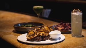 a table with a plate of food and a drink at Lotus Honolulu at Diamond Head in Honolulu