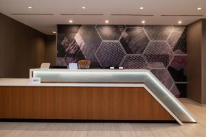 vestíbulo con mostrador de recepción y pared con azulejos en SpringHill Suites by Marriott Kansas City Northeast, en Kansas City