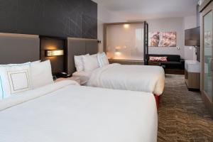 Habitación de hotel con 2 camas y sala de estar. en SpringHill Suites by Marriott Kansas City Northeast, en Kansas City