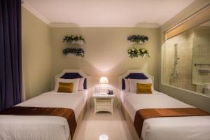 Una cama o camas en una habitación de Amalfi Hotel Seminyak