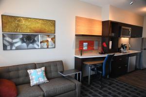 sala de estar con sofá y cocina en TownePlace Suites Kansas City At Briarcliff, en Kansas City