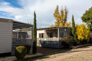 una piccola casa con una recinzione bianca e alberi di hu Roma Camping In Town a Roma