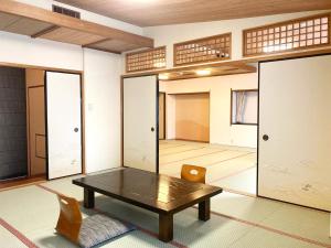 a room with a table and a chair and a room with doors at Itoen Hotel in Ito