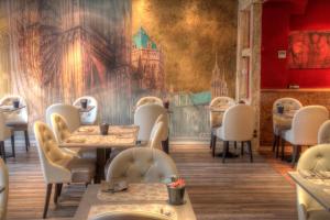 a restaurant with tables and chairs and a mural at Hotel Cathédrale in Strasbourg