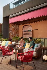 a man and woman sitting at a table on a patio at dusitD2 Samyan Bangkok in Bangkok