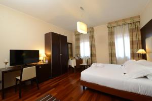 a hotel room with a bed and a flat screen tv at Hotel Guglielmo in Catanzaro