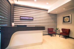 a lobby with a reception desk and two chairs at 33 Boutique Hotel Bandar Sunway in Petaling Jaya