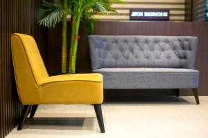 a yellow chair and a blue couch in a room at 33 Boutique Hotel Bandar Sunway in Petaling Jaya