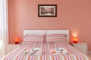 a bedroom with a bed with pink walls and two lamps at B&B Mareya in Cagliari