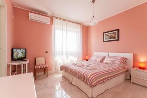 a bedroom with pink walls and a large bed at B&B Mareya in Cagliari