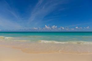 a beach with the ocean and a blue sky w obiekcie Iberostar Waves Punta Cana w Punta Cana