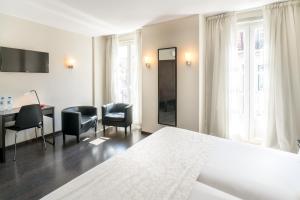 a hotel room with a bed and a table and chairs at Rossio Garden Hotel in Lisbon