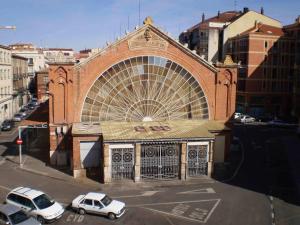 un bâtiment avec deux voitures garées devant lui dans l'établissement Hotel Alda Mercado de Zamora, à Zamora