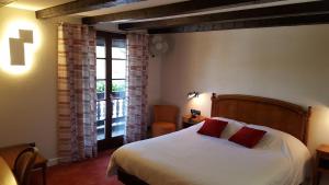 a bedroom with a bed and a large window at Hotel Restaurant Père Benoît in Entzheim