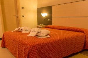 two beds in a hotel room with towels on them at Albergo della Posta in Taverna