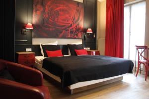 a bedroom with a large bed with red pillows at Hotel Roses in Strasbourg