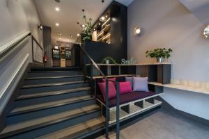 a lobby with stairs with a purple chair at Campanile Annecy Centre - Gare in Annecy