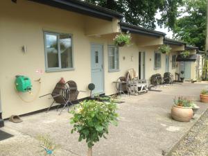 a group of chairs sitting outside of a house at The Stables - Deer Park Farm in Solihull