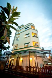 a tall white building with a fence in front of it at 皇裔民宿 - 歐式小屋 in Hualien City