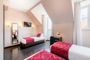 a hotel room with two beds and a mirror at Rossio Garden Hotel in Lisbon