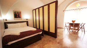 a bedroom with a bed and a table and chairs at The Market Courtyard - Suites Hotel in Jerusalem