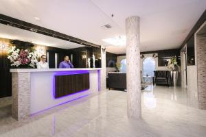 eine Lobby mit einer Bar mit lila Beleuchtung in der Unterkunft Ocean Beach Club in Fort Lauderdale