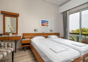 1 dormitorio con 2 camas, escritorio y ventana en Park Hotel, en Atenas